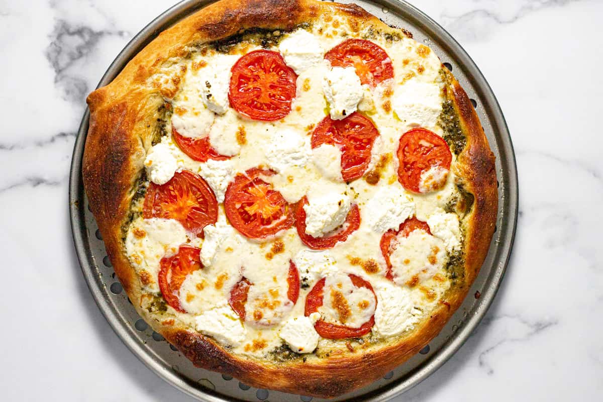 Freshly baked Caprese pizza on a pizza pan