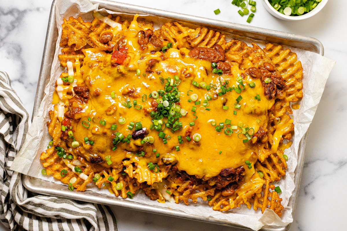 Freshly baked chili cheese fries garnished with green onion