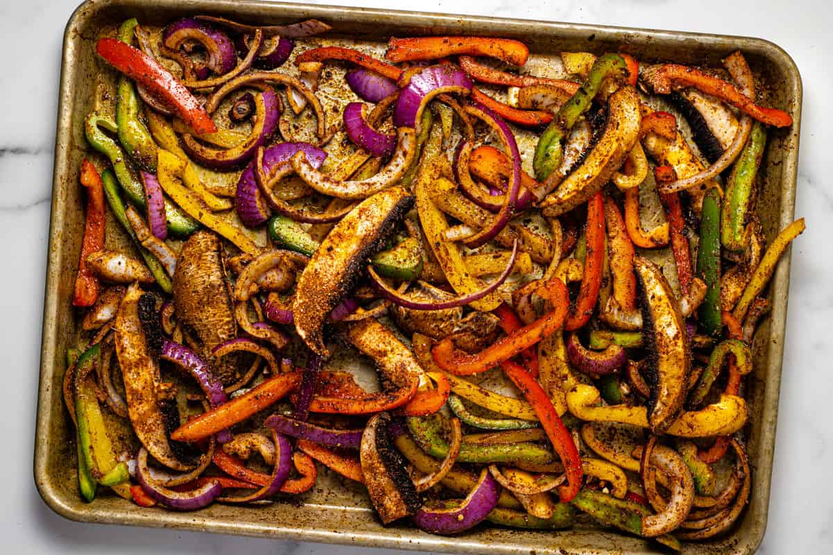 Baking sheet filled with fajita veggies ready to go in the oven
