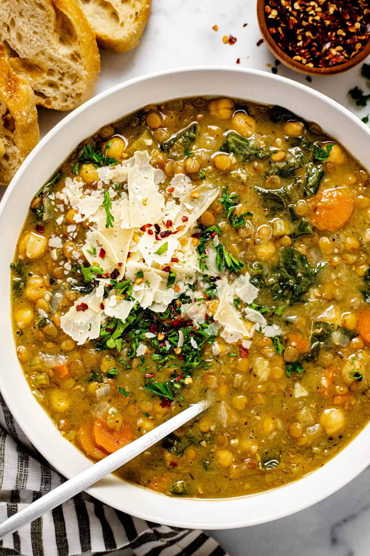 White bowl filled with creamy vegan instant pot lentil soup garnished with fresh parsley