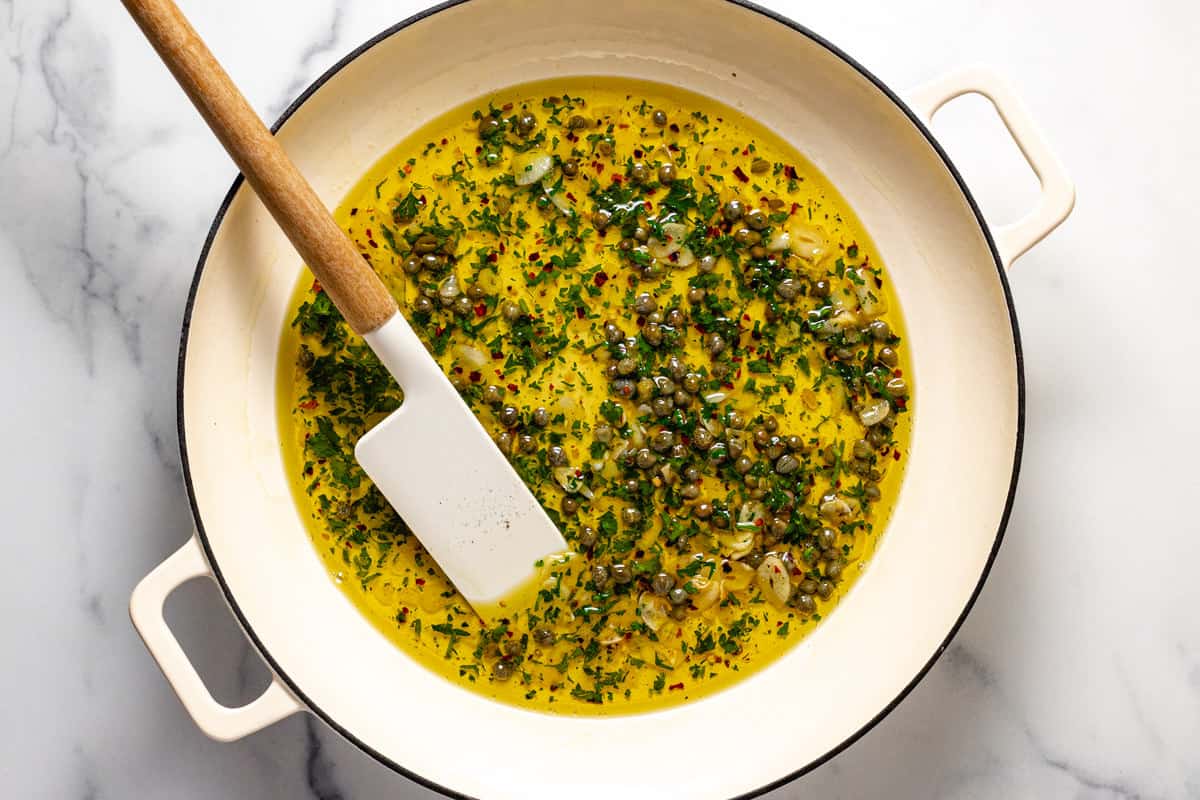 Olive oil in a large pan along with capers parsley and garlic
