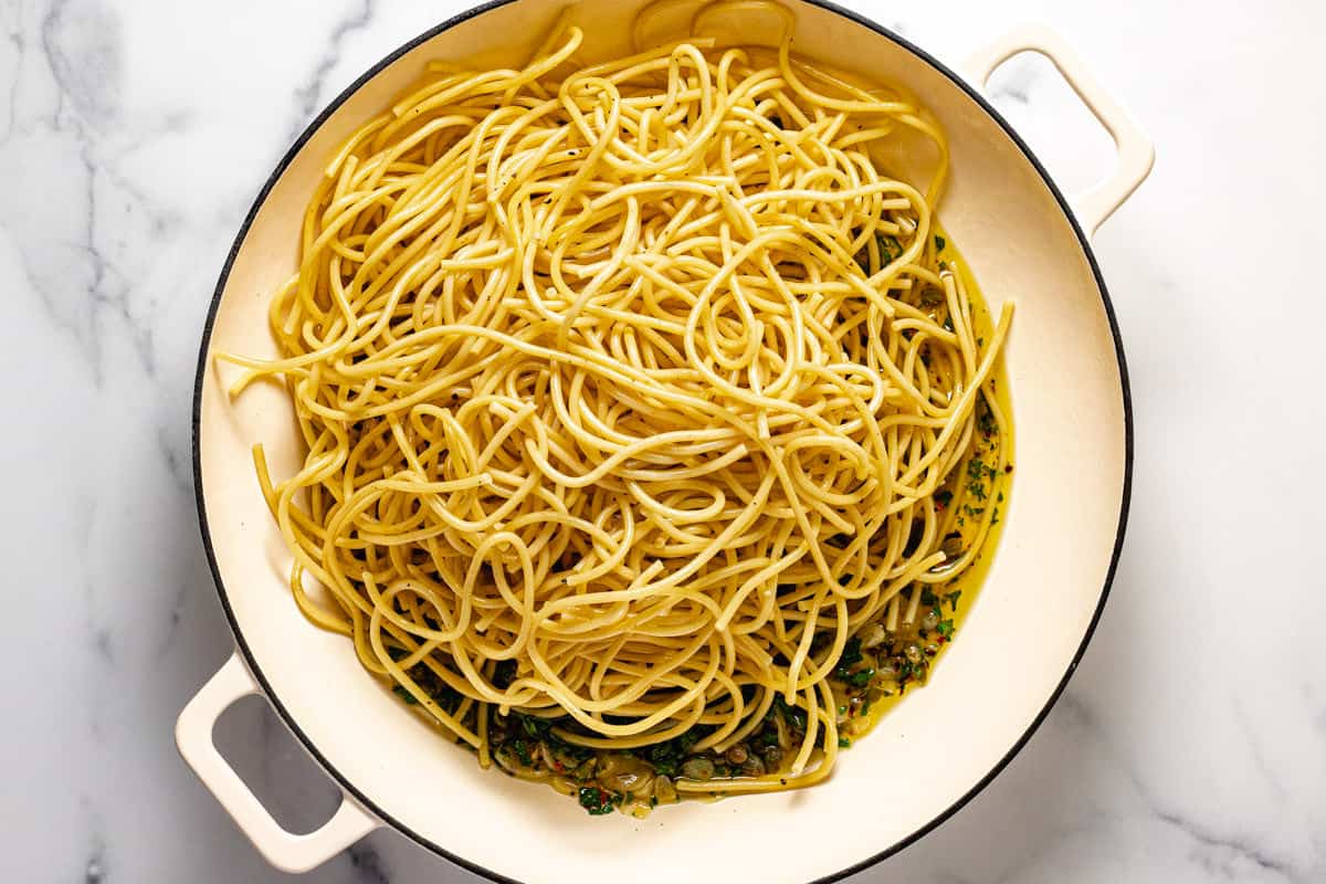 Ingredients to make olive oil pasta in a large sauté pan