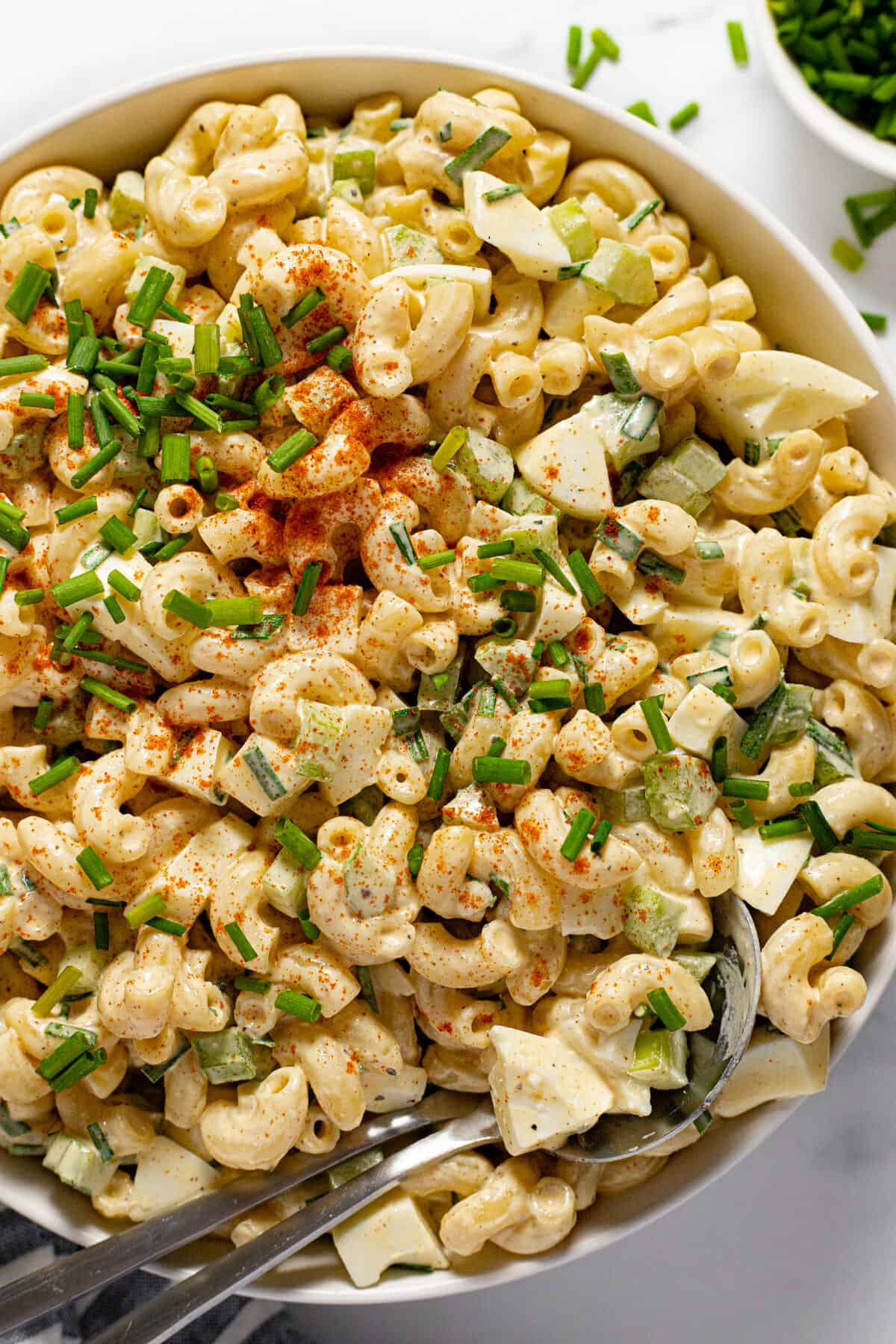 White bowl filled with creamy homemade deviled egg macaroni salad