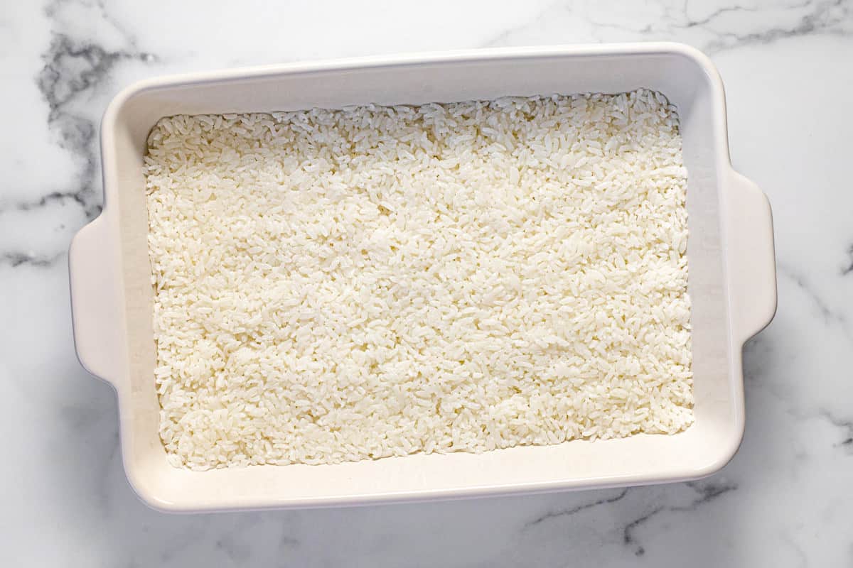 Large white casserole dish filled with cooked sushi rice