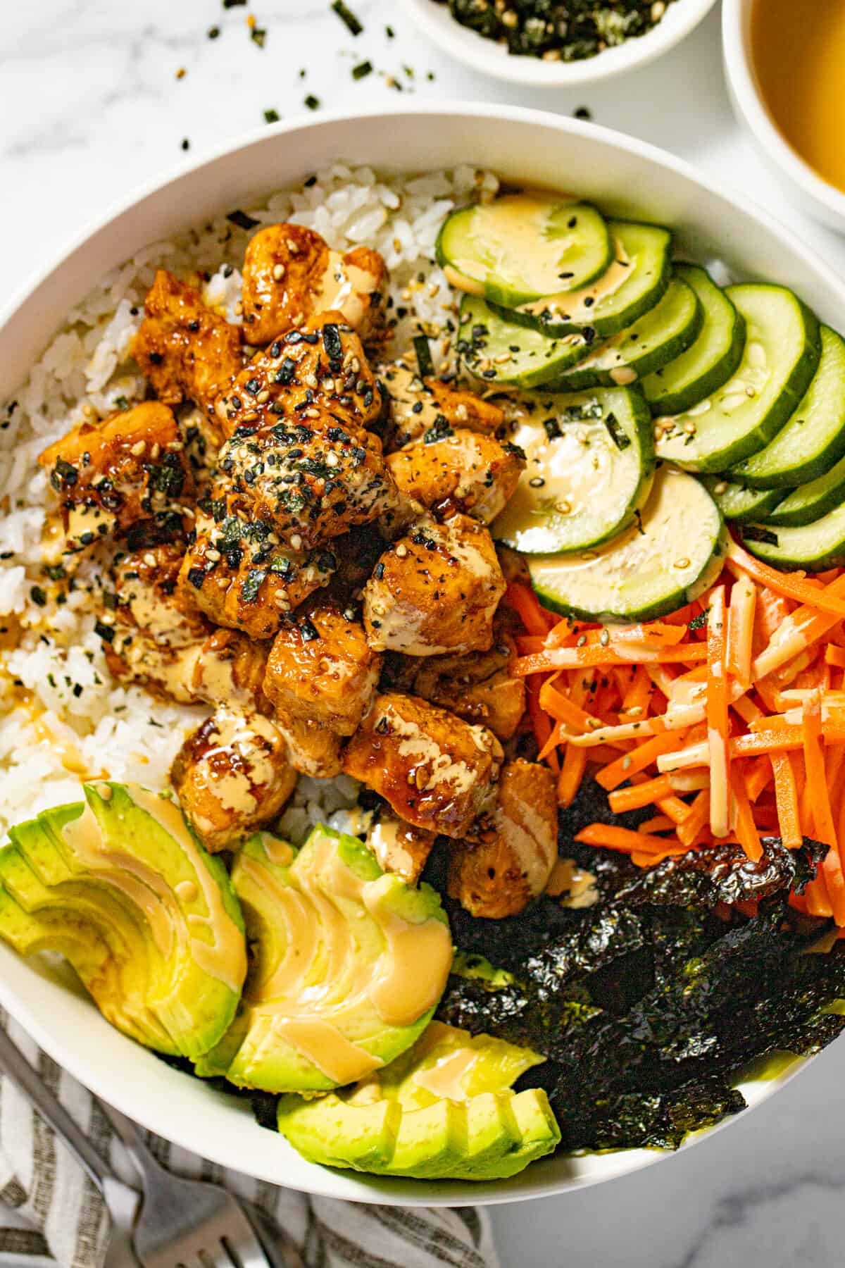 White bowl with a homemade sesame salmon bowl garnished with Furikake.
