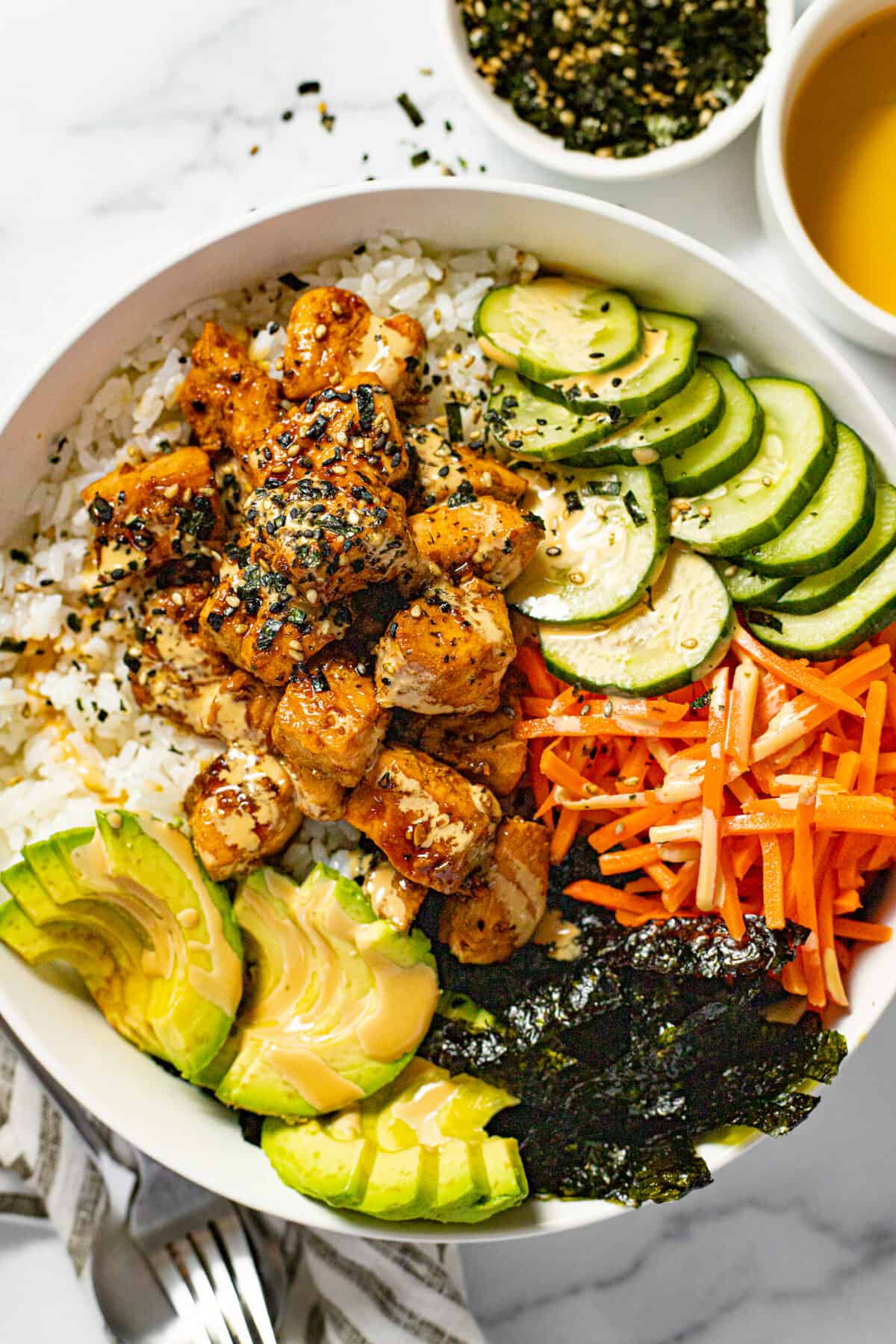 White bowl with a homemade sesame salmon bowl garnished with Furikake.