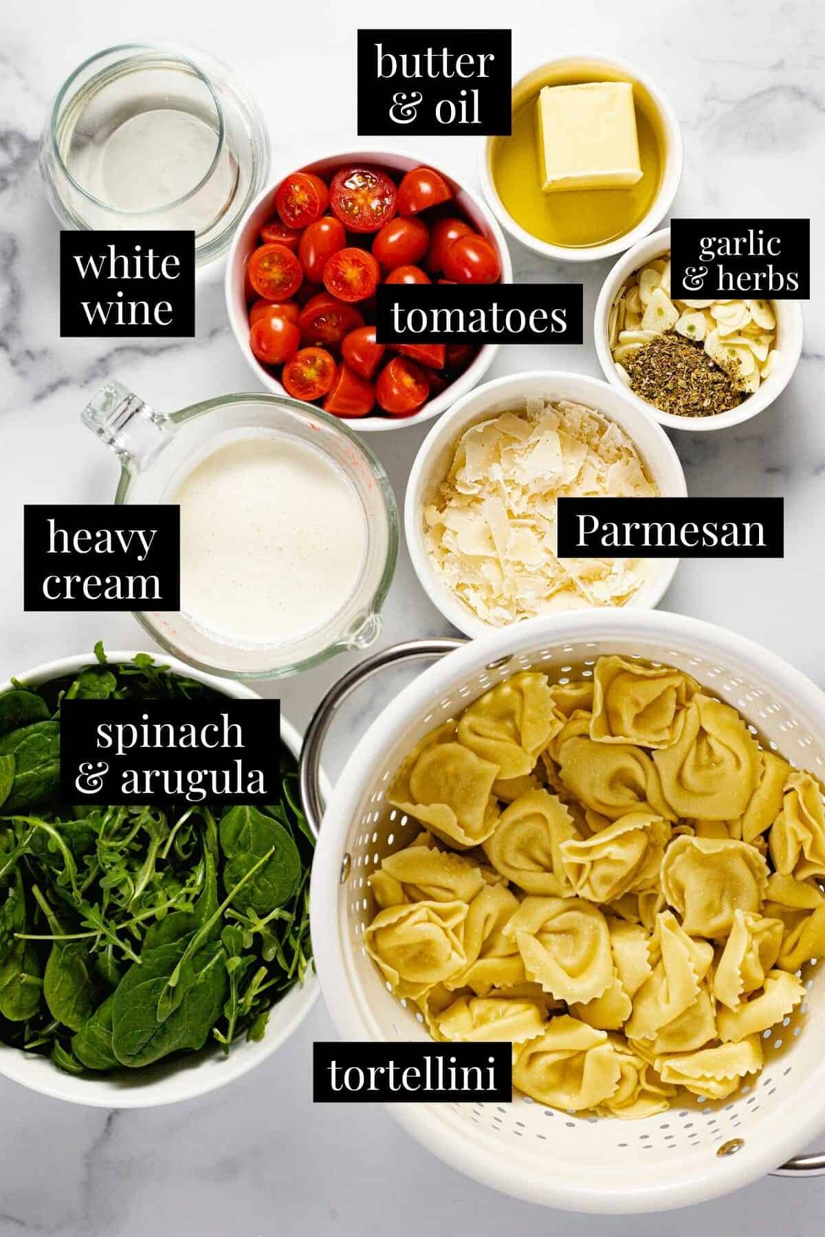 White marble counter top with bowls of ingredients to make cheese tortellini with cream sauce