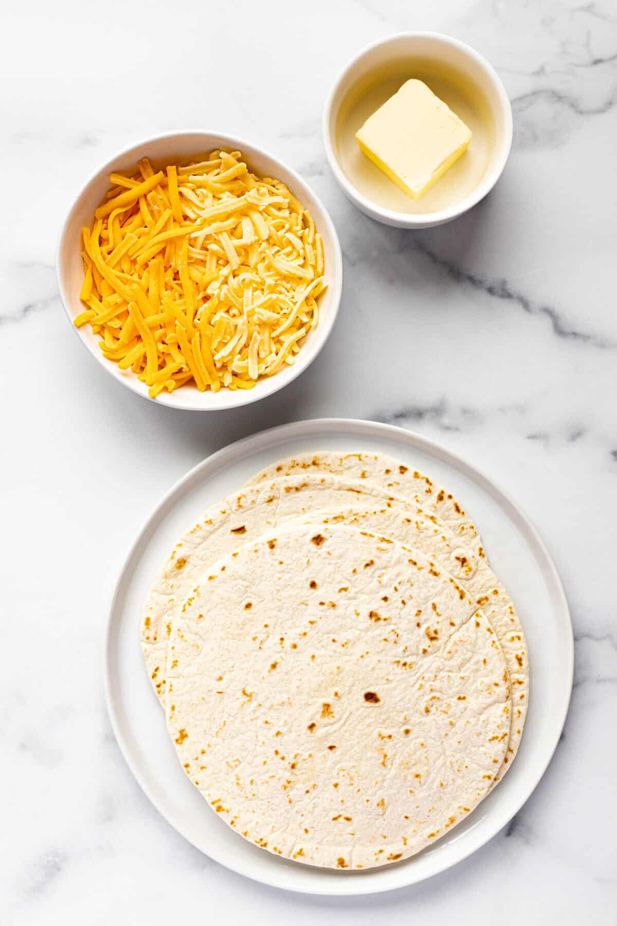 White marble counter top with ingredients to make easy cheese quesadillas