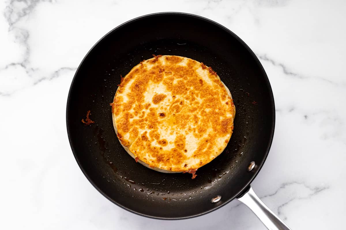 Black skillet with a homemade cheese quesadilla in it