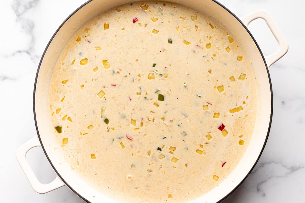 Large white pan with cheesy cream sauce and veggies