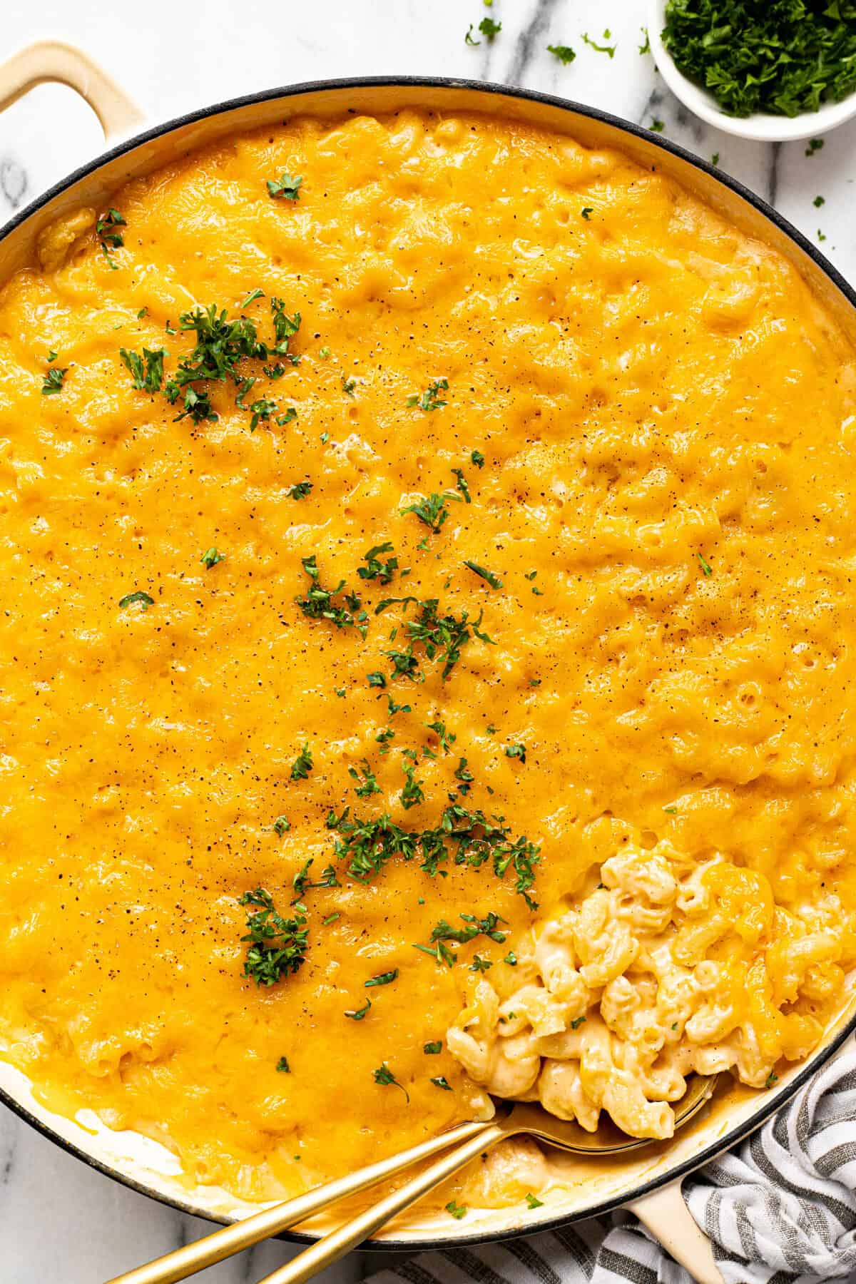 Large white pan filled with creamy homemade smoked mac and cheese garnished with parsley