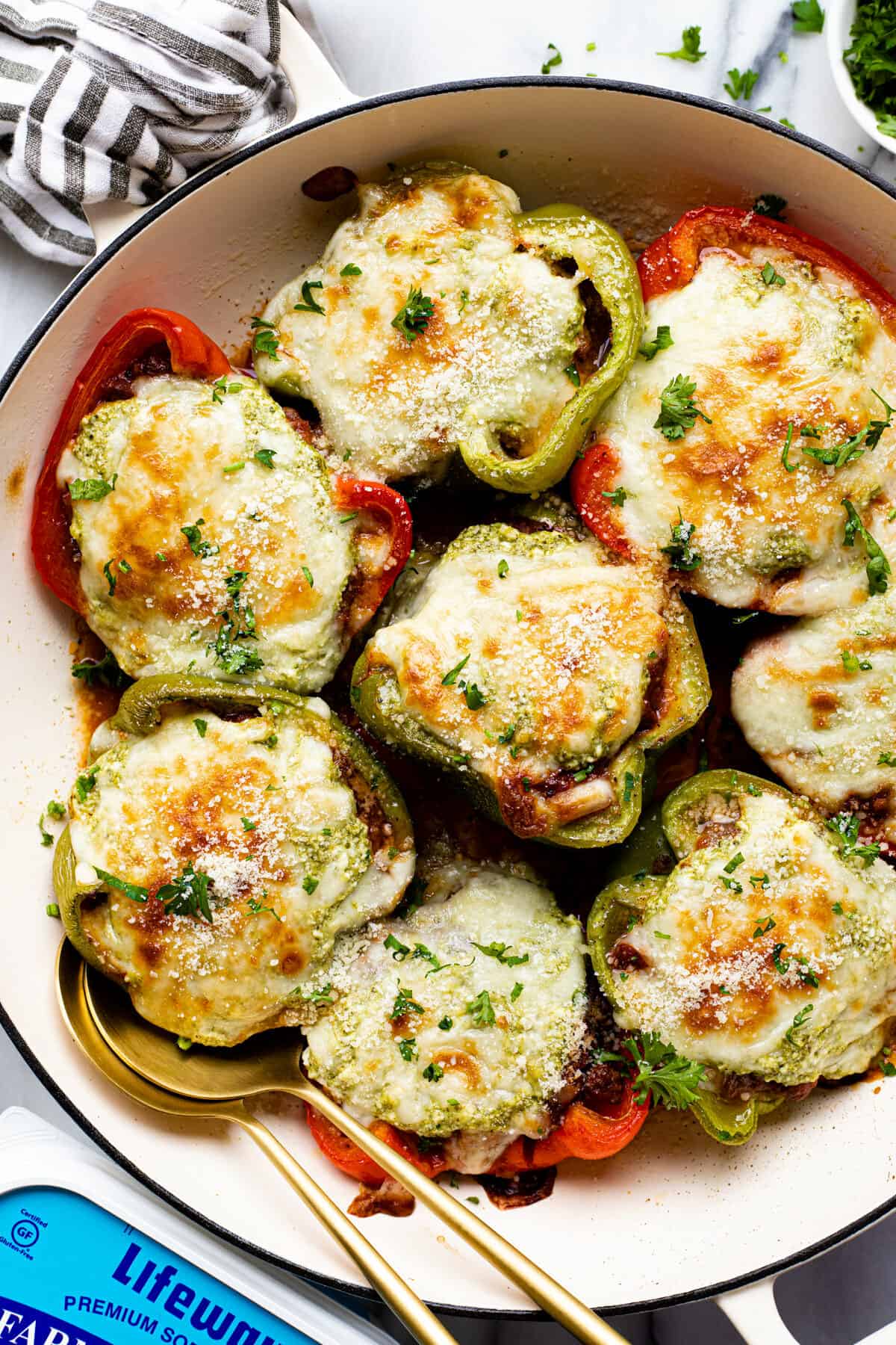 Large white pan filled with Italian stuffed peppers garnished with parsley.