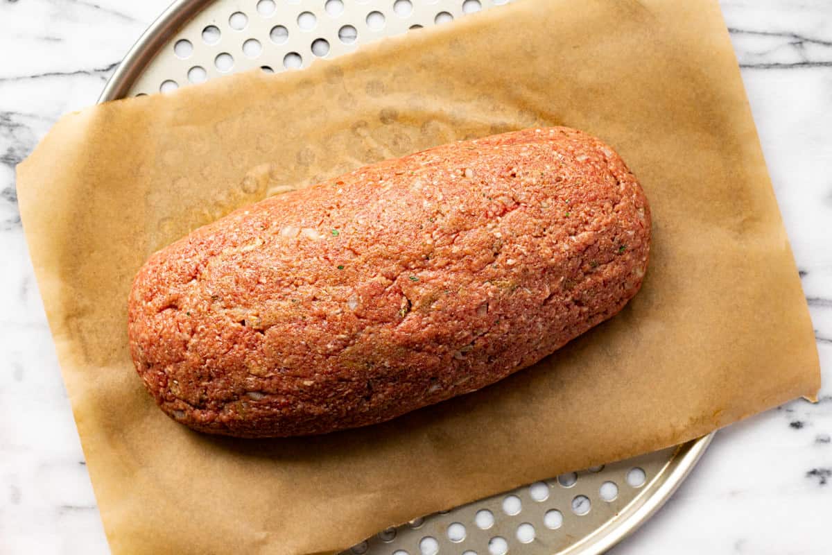 Meatloaf on a parchment lined pizza pan.