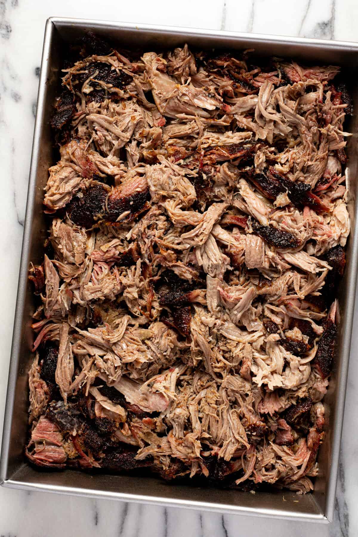 Large metal pan of shredded pork butt