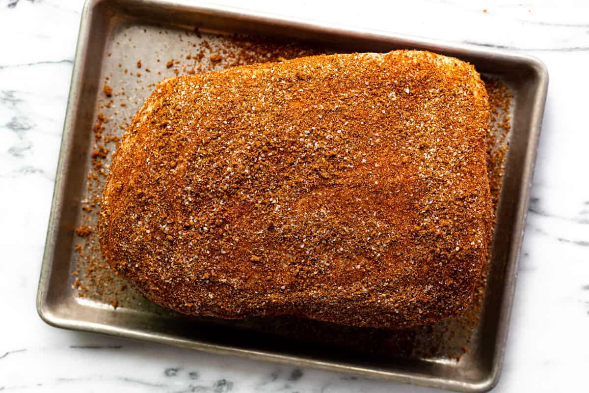 Seasoned pork butt on a metal sheetpan