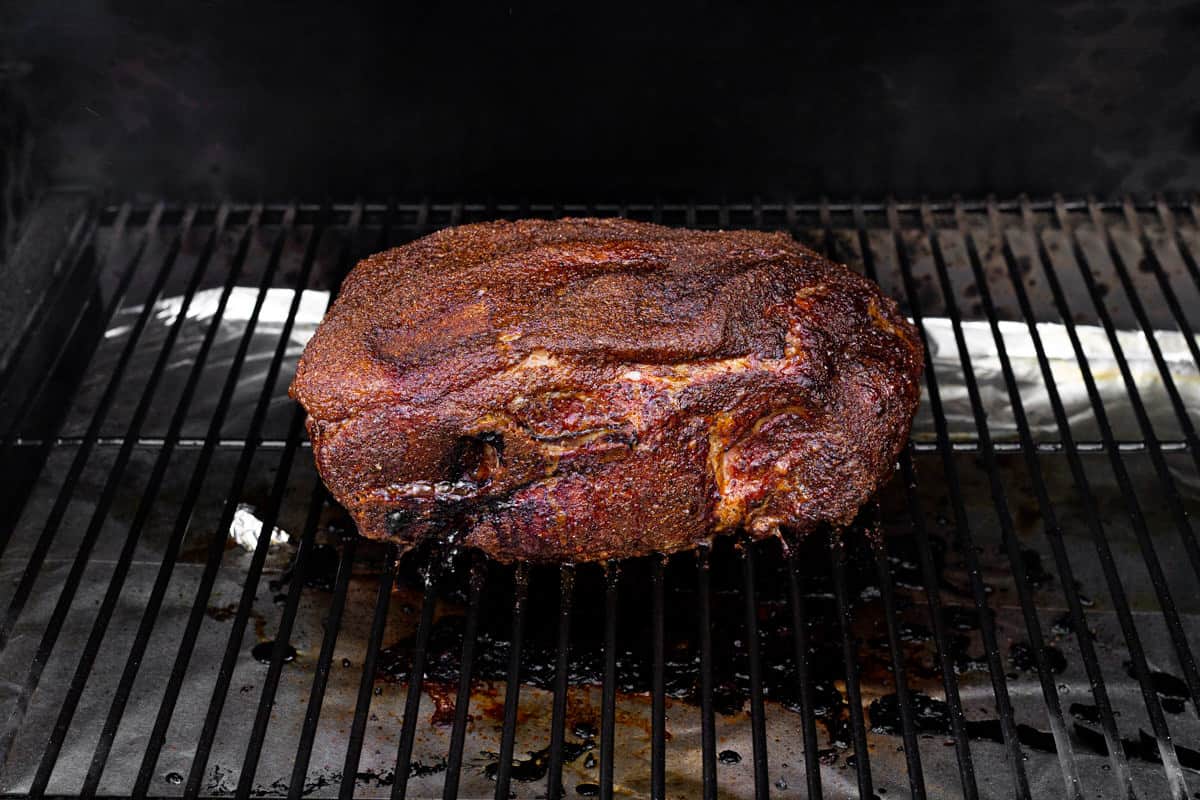 Smoked pork butt on a grill grate.