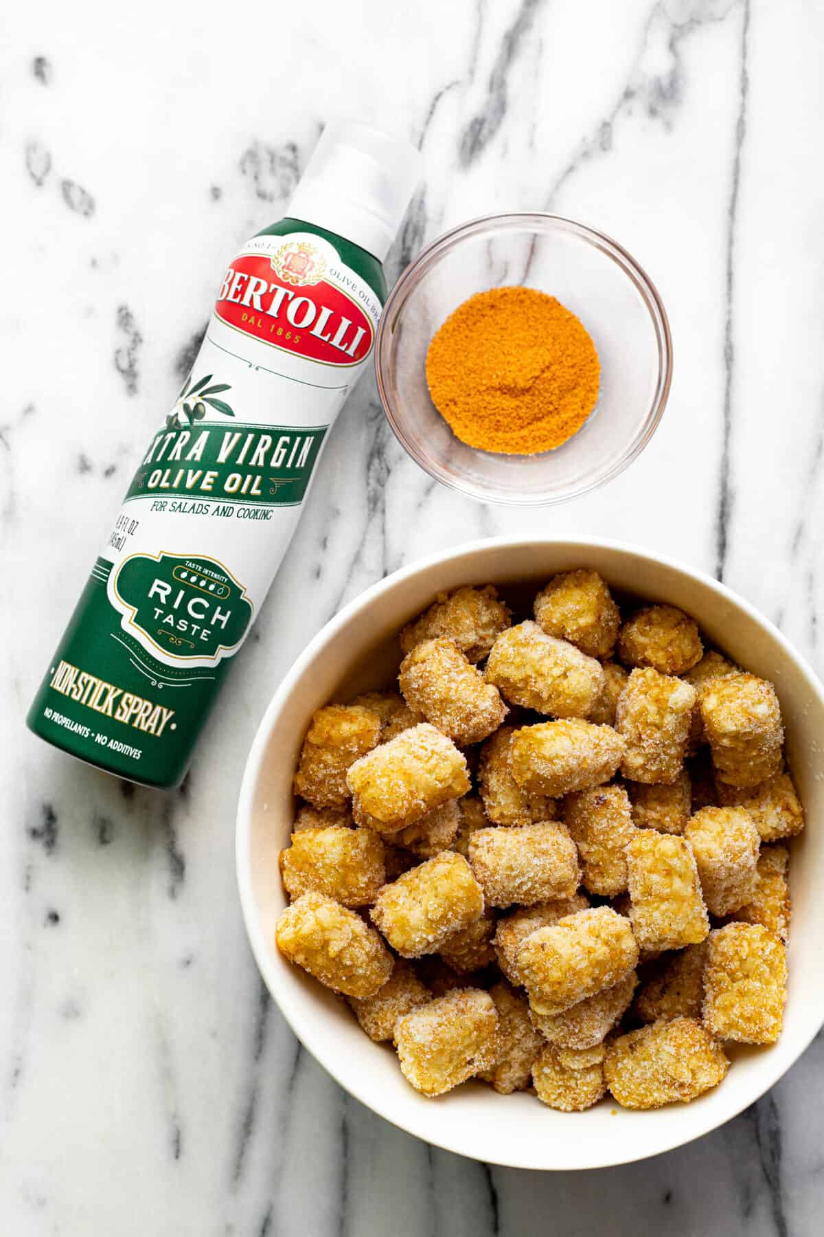 White marble counter top with ingredients to make air fryer tater tots recipe.