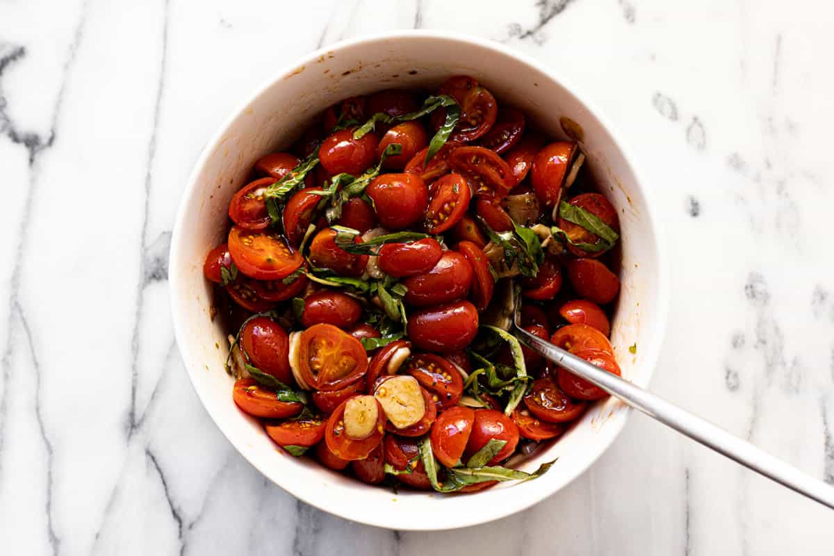 Marinated tomatoes in a white bowl.
