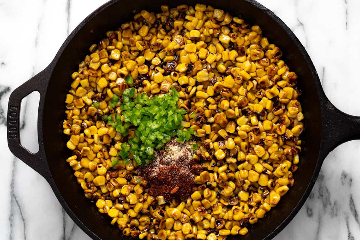 Large cast iron pan charred corn, diced jalapenos, and spices.