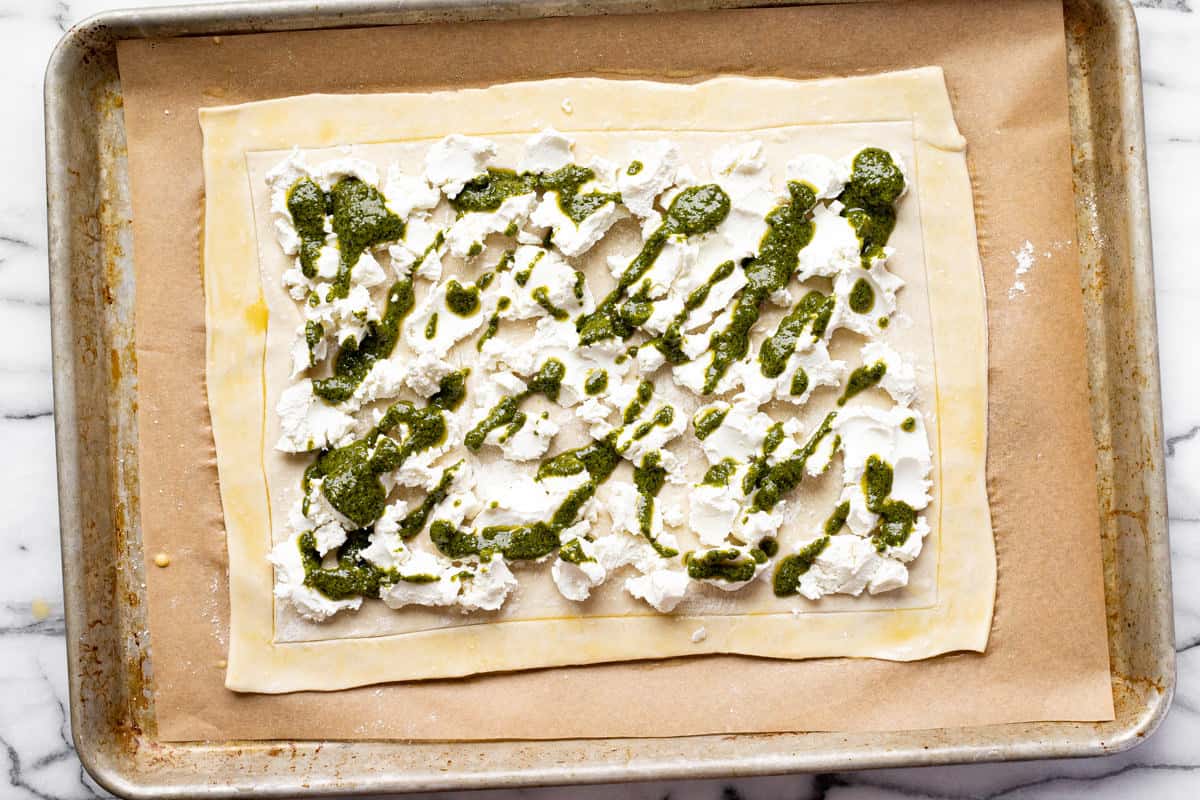 Farmer cheese and pesto spread across a rectangle of puff pastry.
