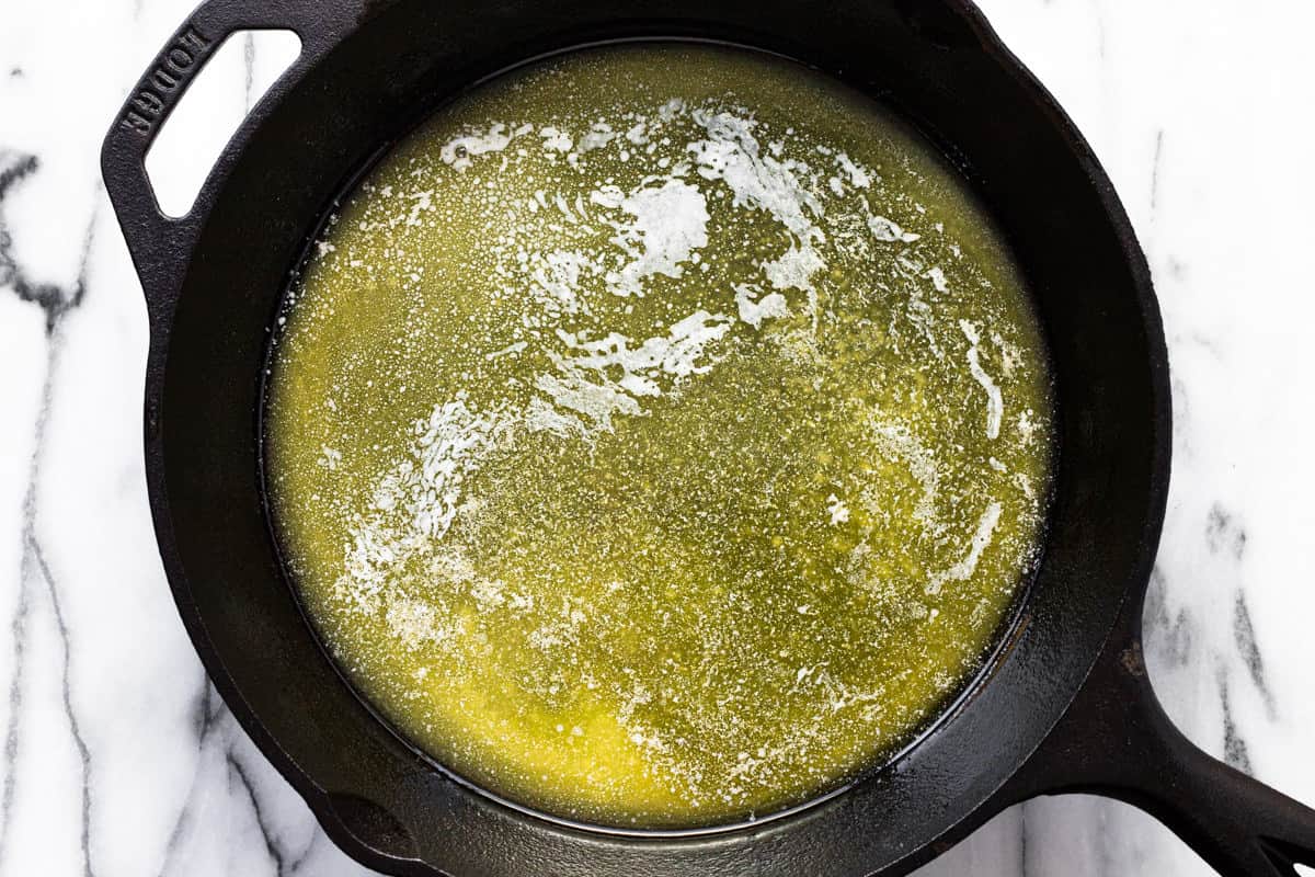 Large cast iron pan filled with melted butter.
