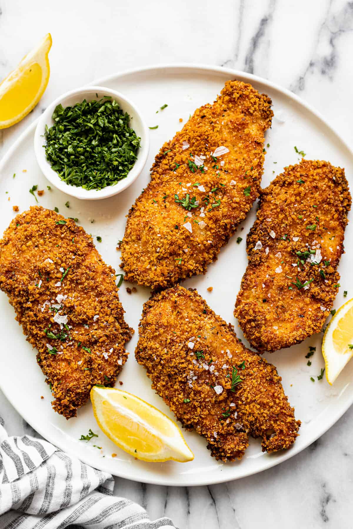 White plate filled with Panko crusted chicken breast.