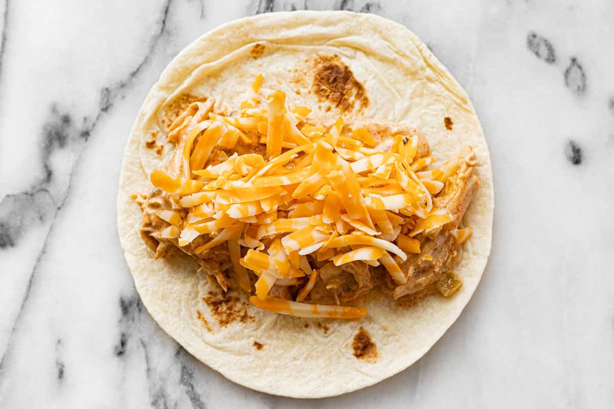 Flour tortilla topped with creamy shredded chicken and shredded cheese.