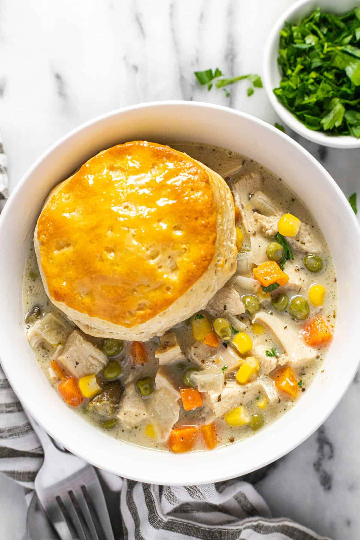 White bowl filled with creamy homemade crock pot chicken pot pie.