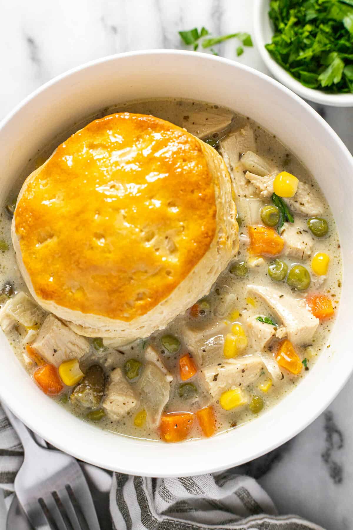 White bowl filled with creamy homemade crock pot chicken pot pie.