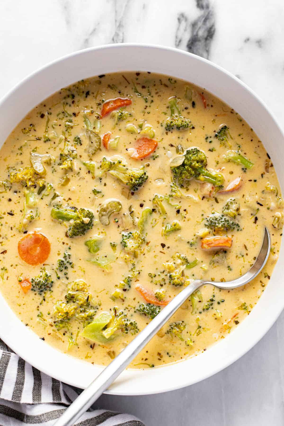 White bowl filled with homemade broccoli cheddar soup.