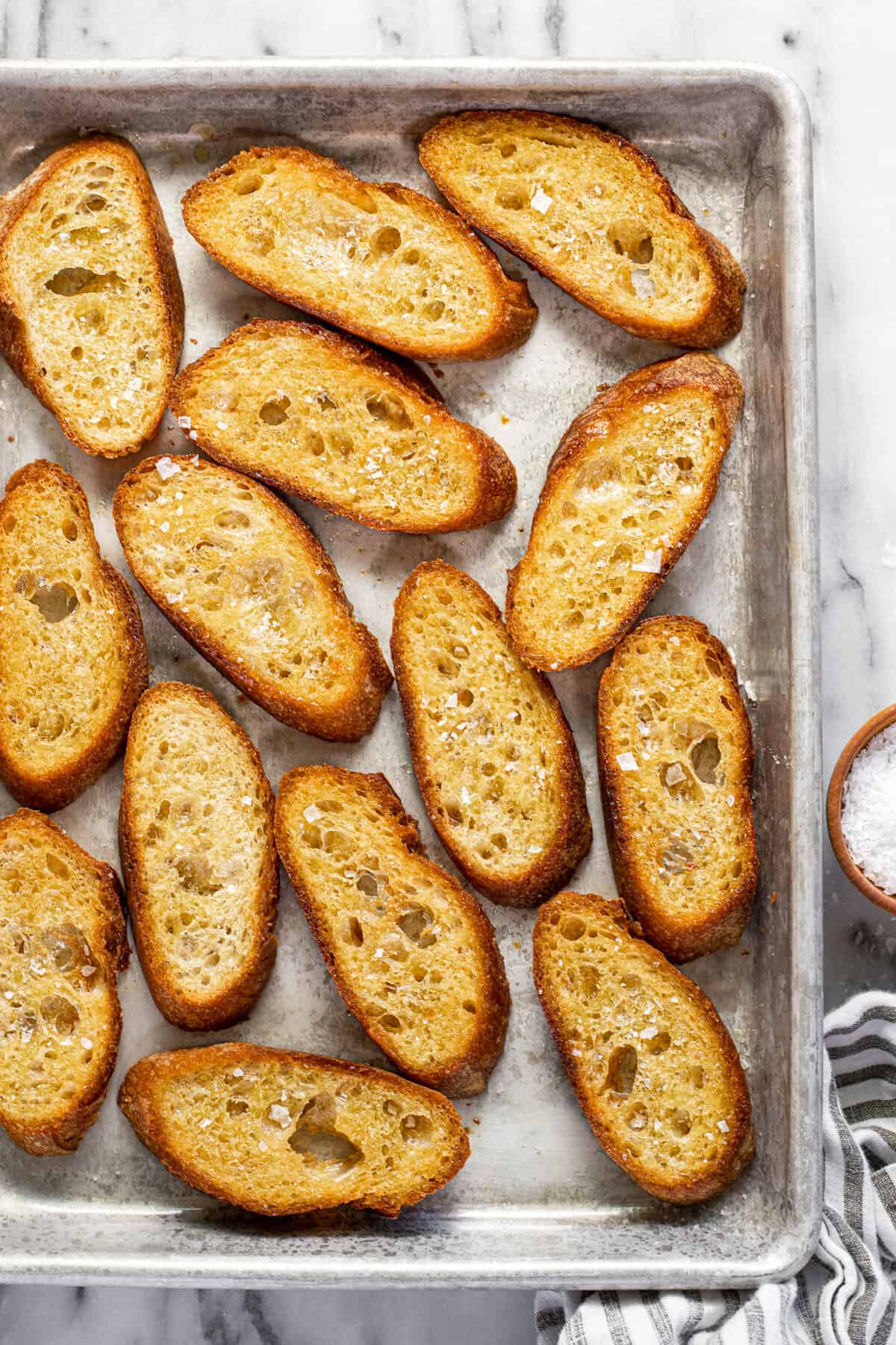 A baking sheet filled with crispy homemade crostini.