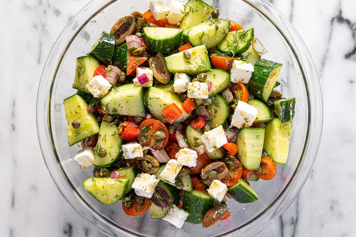 Large glass bowl filled with homemade Greek salad. 
