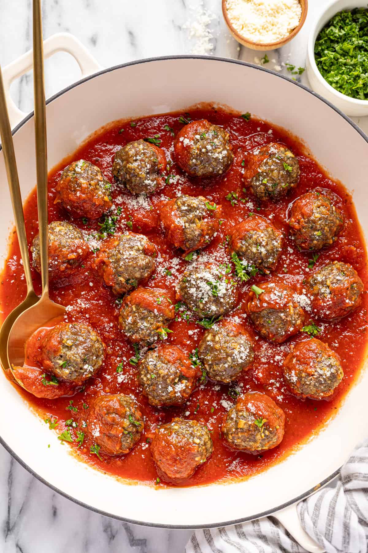 Large white pan filled with homemade Italian meatballs in marinara sauce.
