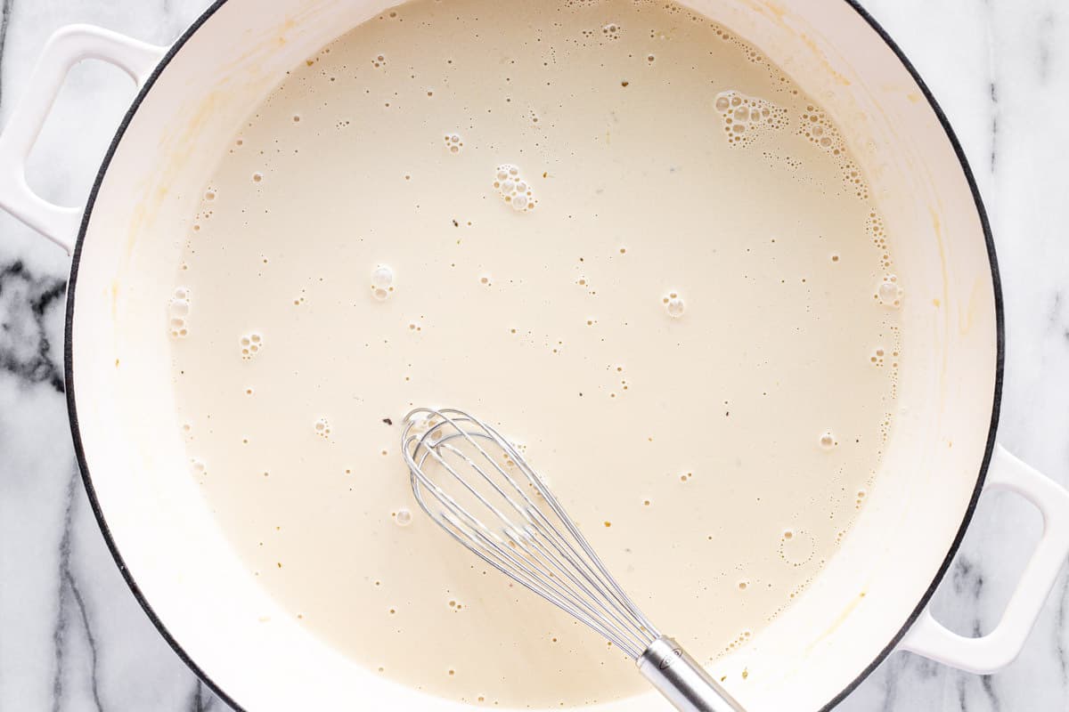 The start of a creamy alfredo sauce in a large white pan.