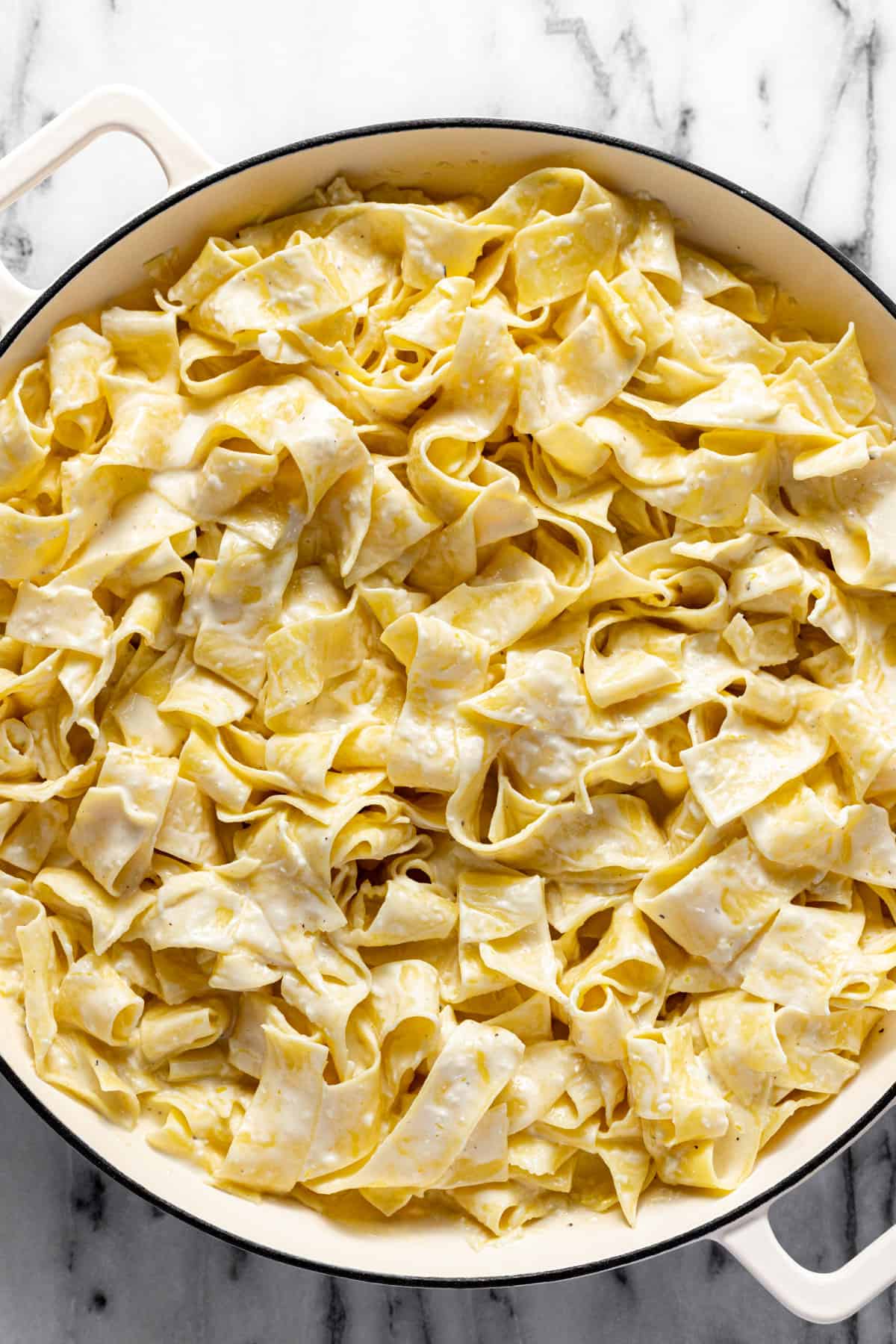 Large white pan filled with creamy lemon pappardelle pasta.