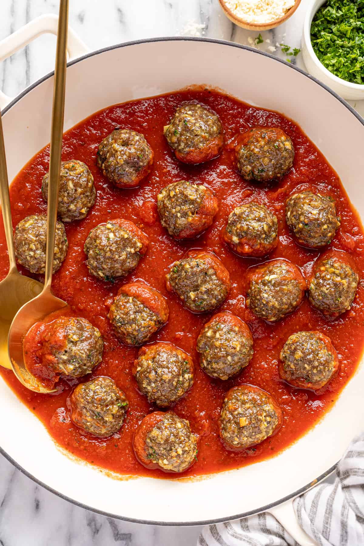 Large white saute pan filled with air fryer meatballs and marinara sauce.