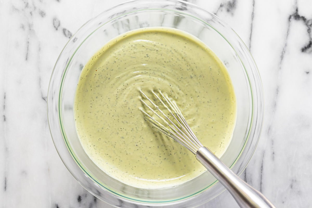 Big glass bowl filled with creamy homemade avocado ranch dressing.