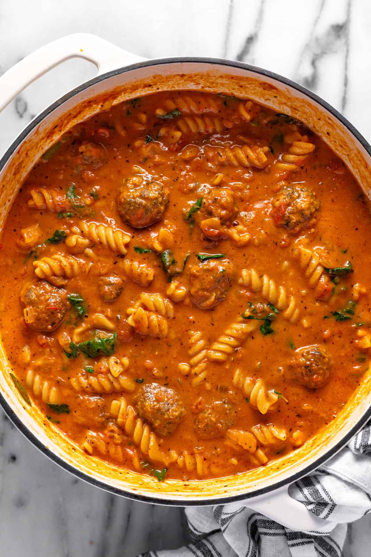 Large white pot filled with creamy homemade meatball pasta soup.
