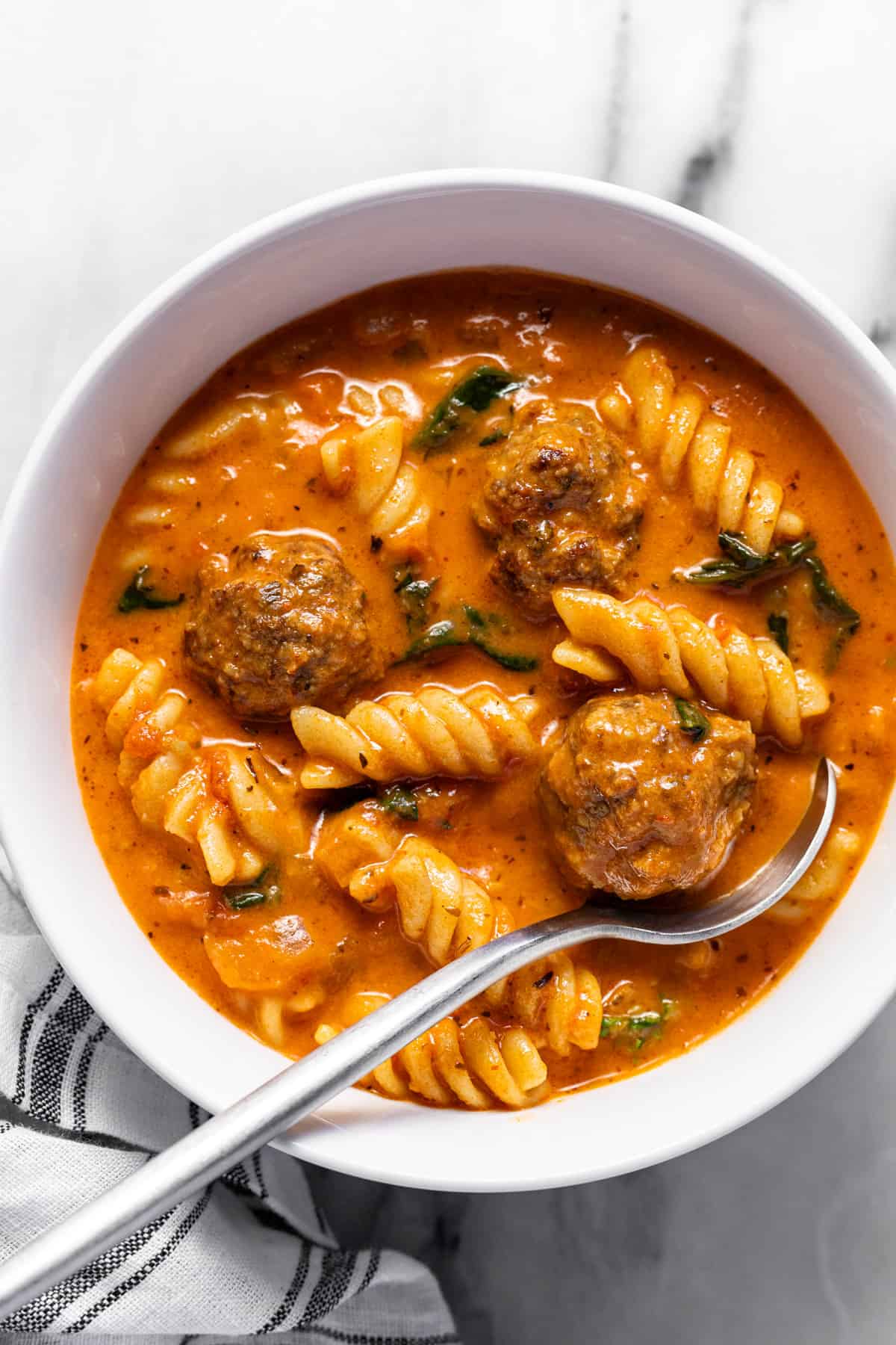 White bowl filled with homemade creamy Italian meatball soup.
