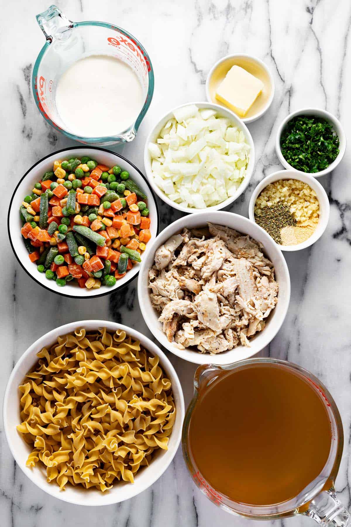 Bowls of ingredients to make creamy homemade chicken and noodles. 