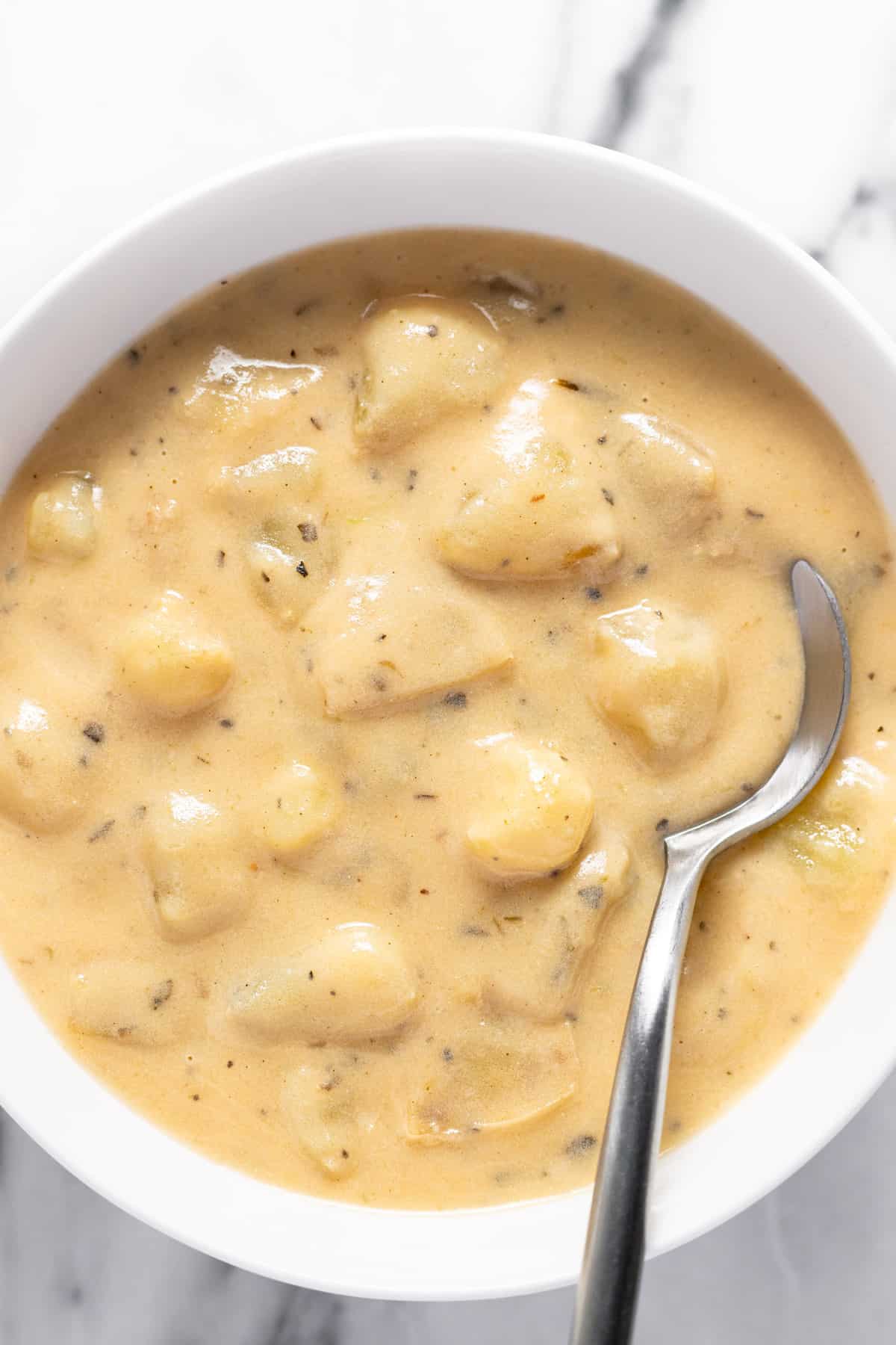 Small bowl filled with creamy potato soup and a spoon.