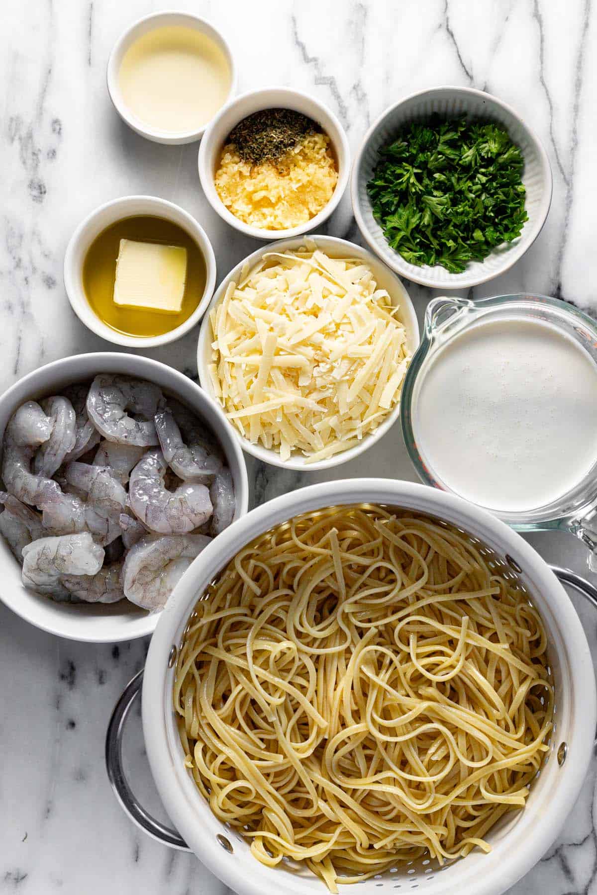 Bowls of ingredients to make shrimp pasta. 