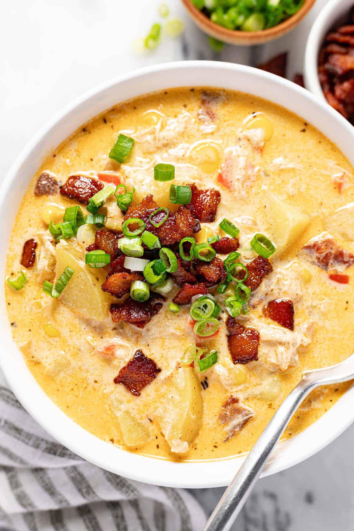 Bowl of chicken corn chowder garnished with bacon and green onion. 