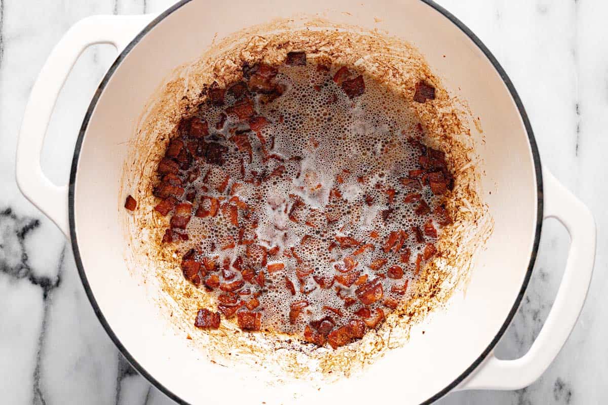 Large pot filled with crispy squares of cooked bacon.