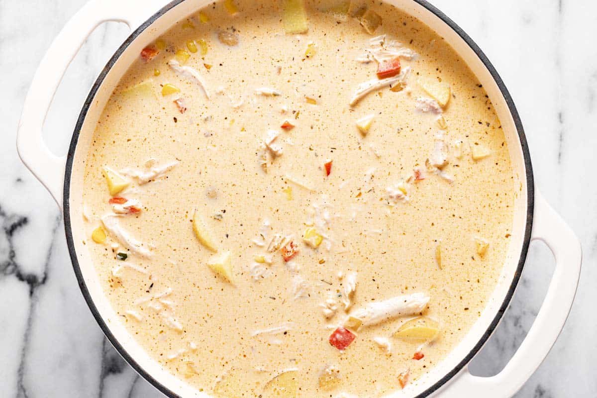 Large pot filled with ingredients to make one pot creamy chicken corn chowder. 