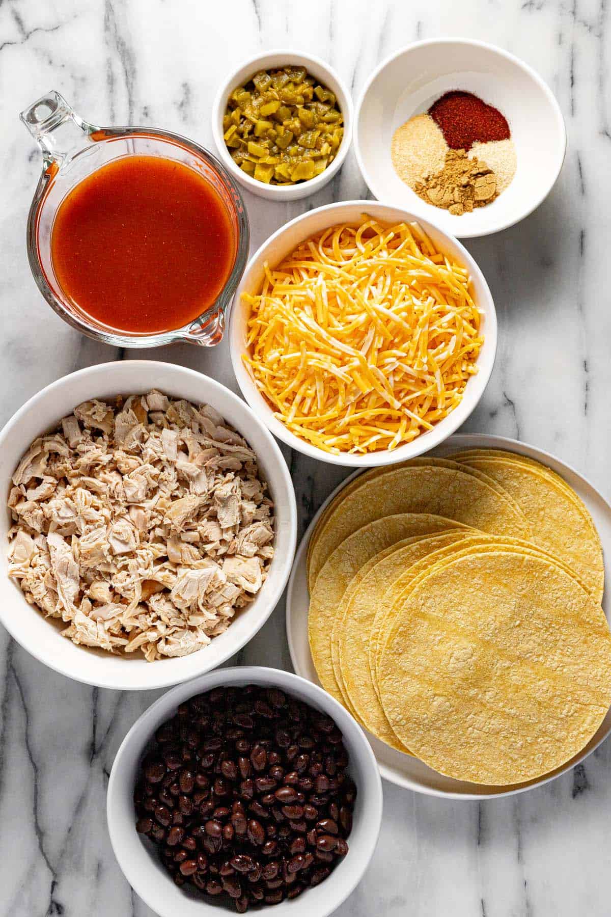 Bowls of ingredients to make chicken enchilada casserole. 