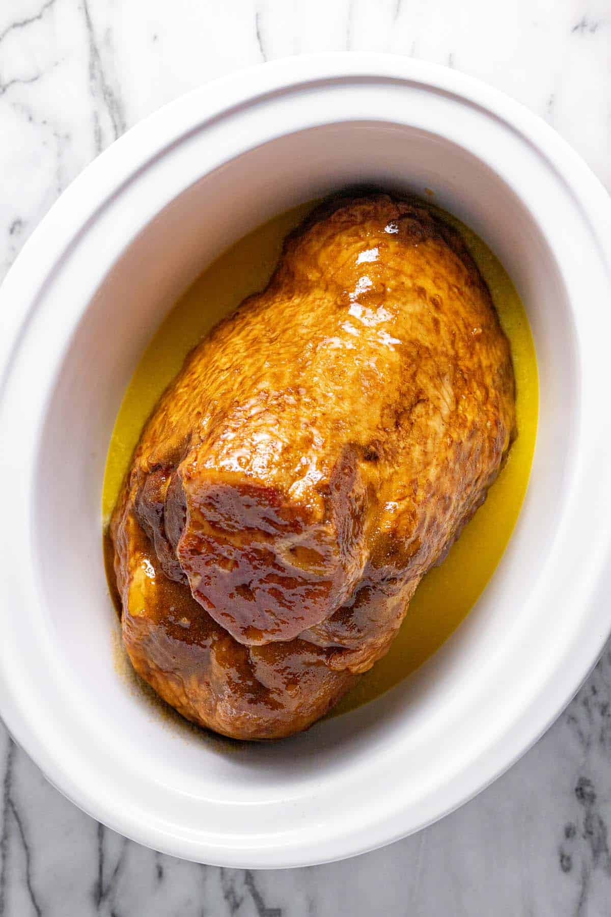 Large crock pot insert with a glazed ham inside. 