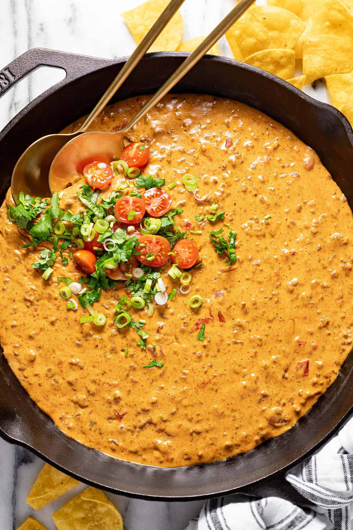 Big cast iron pan filled with homemade cheesy Rotel dip. 