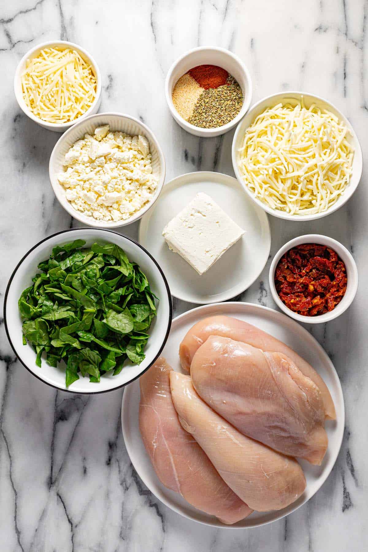 Bowls of ingredients to make Mediterranean stuffed chicken breast. 