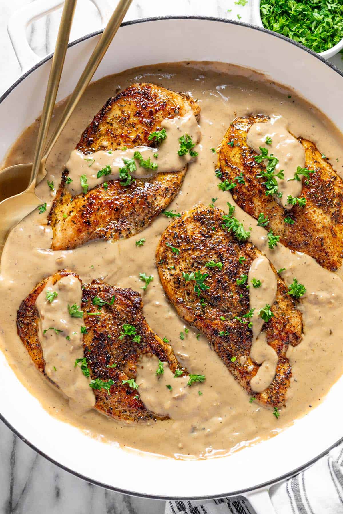 Large pan filled with sauteed chicken and creamy sauce. 